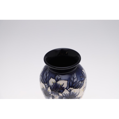 759 - MODERN MOORCROFT TRIAL VASE - ASTROMERIA. The vase of tapering form and painted with flowers on a bl... 