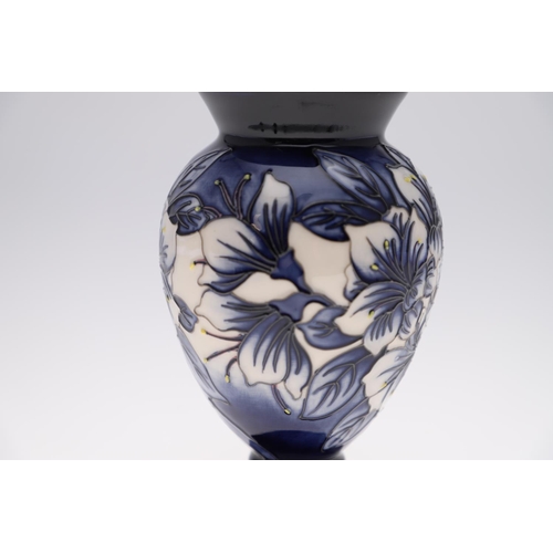 759 - MODERN MOORCROFT TRIAL VASE - ASTROMERIA. The vase of tapering form and painted with flowers on a bl... 