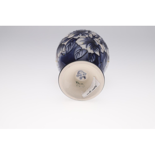 759 - MODERN MOORCROFT TRIAL VASE - ASTROMERIA. The vase of tapering form and painted with flowers on a bl... 