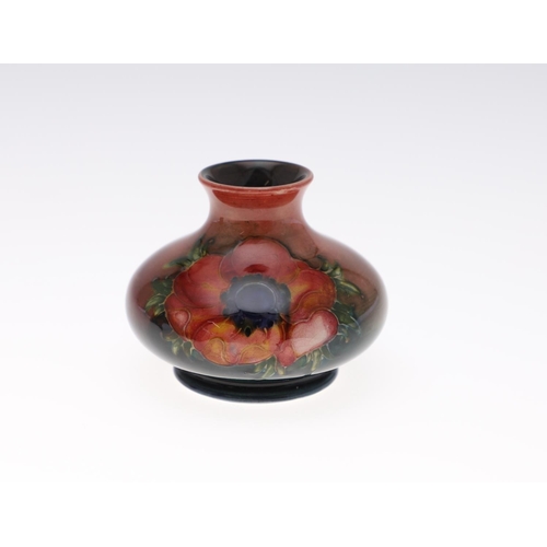 761 - MOORCROFT FLAMBE VASE & LIDDED BOX. A small squat vase painted in the Anemone design with a flambe g... 