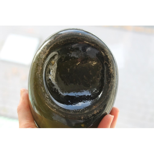 781 - 18THC GLASS BOTTLE. An olive green bottle with a tapering neck and string rim, the body of flattened... 