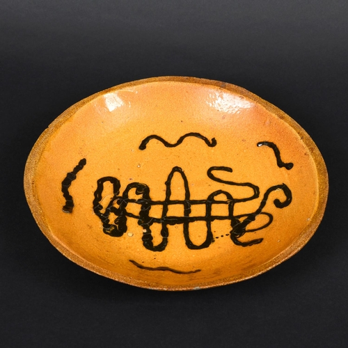 794 - ENGLISH SLIPWARE DISH. Probably 18thc, the deep dish with trails of black slip on an ochre glazed gr... 