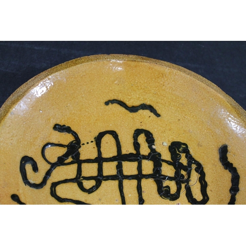 794 - ENGLISH SLIPWARE DISH. Probably 18thc, the deep dish with trails of black slip on an ochre glazed gr... 