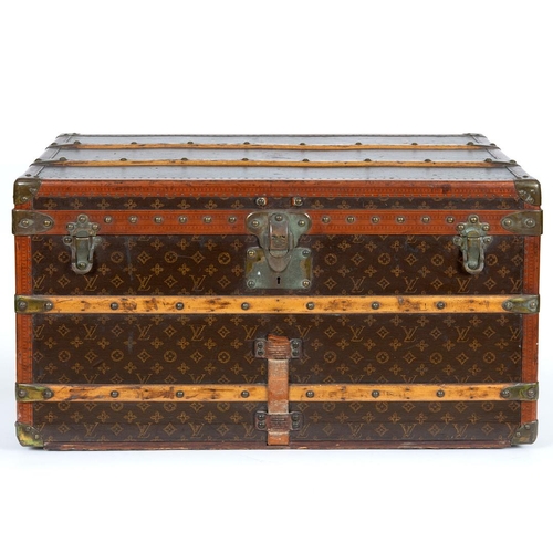 572 - VINTAGE LOUIS VUITTON TRUNK. A vintage early 20thc trunk with monogrammed exterior, with wooden slat... 