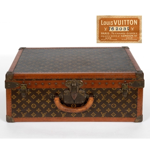 573 - VINTAGE LOUIS VUITTON SUITCASE. With a monogrammed exterior, leather trim with brass studs and brass... 