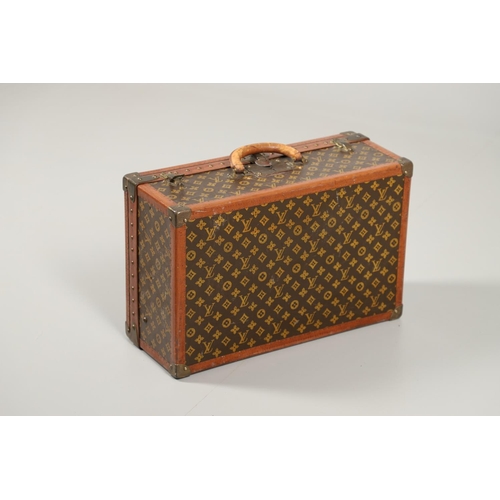 573 - VINTAGE LOUIS VUITTON SUITCASE. With a monogrammed exterior, leather trim with brass studs and brass... 