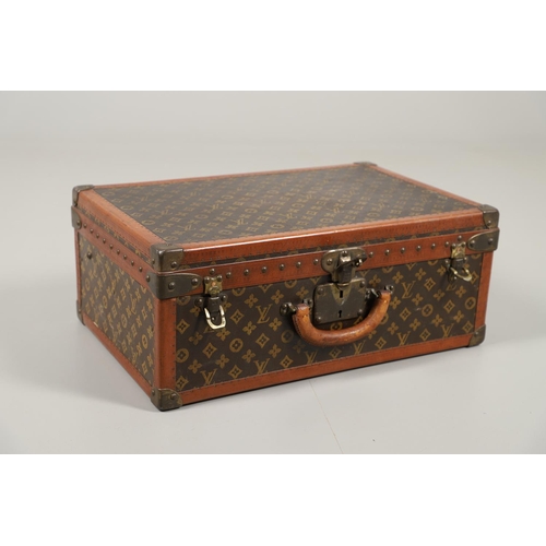 573 - VINTAGE LOUIS VUITTON SUITCASE. With a monogrammed exterior, leather trim with brass studs and brass... 