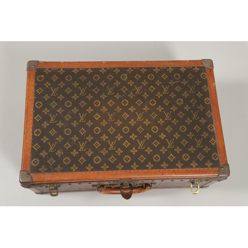 573 - VINTAGE LOUIS VUITTON SUITCASE. With a monogrammed exterior, leather trim with brass studs and brass... 