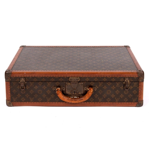 574 - VINTAGE LOUIS VUITTON SUITCASE. An early 20thc suitcase, with a monogrammed exterior, leather trim w... 