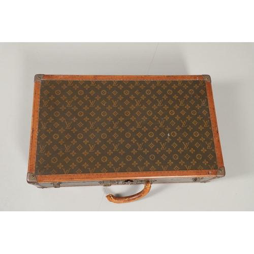 574 - VINTAGE LOUIS VUITTON SUITCASE. An early 20thc suitcase, with a monogrammed exterior, leather trim w... 