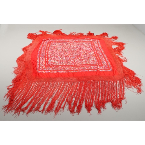 575 - CHINESE SILK SHAWL. A late 19thc/early 20thc red silk shawl, embroidered with small figures, buildin... 