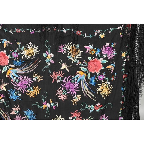 591 - CHINESE SILK EMBROIDERED SHAWL. A black silk shawl, the central panel brightly embroidered with bird... 