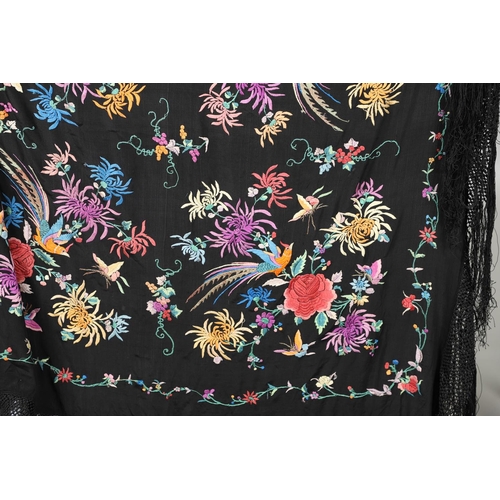 591 - CHINESE SILK EMBROIDERED SHAWL. A black silk shawl, the central panel brightly embroidered with bird... 