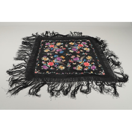 591 - CHINESE SILK EMBROIDERED SHAWL. A black silk shawl, the central panel brightly embroidered with bird... 