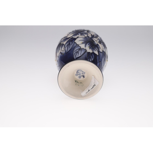 726 - MODERN MOORCROFT TRIAL VASE - ASTROMERIA. The vase of tapering form and painted with flowers on a bl... 