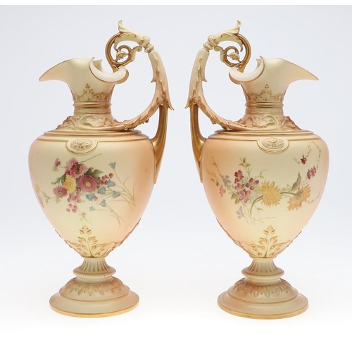 800 - LARGE PAIR OF ROYAL WORCESTER EWERS. A pair of blush ivory ewers, with acanthus shaped handle and th... 