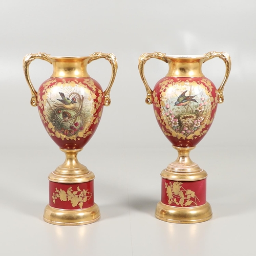 804 - LARGE PAIR OF CONTINENTAL PEDESTAL URNS. A pair of twin handled urns, each painted with Birds amongs... 