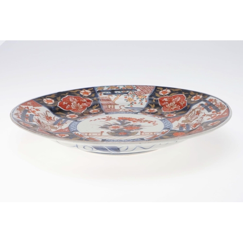 844 - 19THC JAPANESE IMARI DISH. A late 19thc Japanese Imari dish, painted in the centre with a vase of fl... 