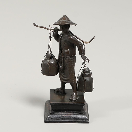 846 - SOUTH EAST ASIAN BRONZE FISHERMAN. A bronze figure of a Fisherman, carrying two storage jars suspend... 