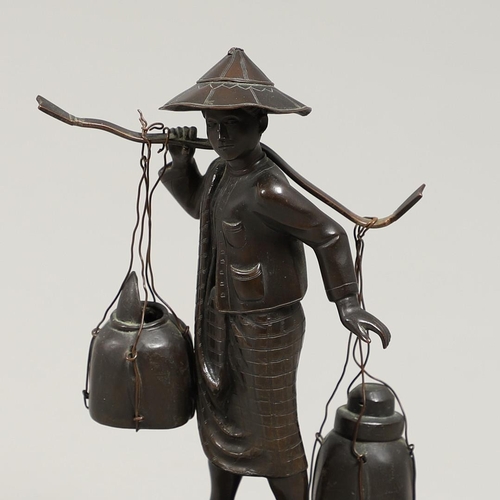 846 - SOUTH EAST ASIAN BRONZE FISHERMAN. A bronze figure of a Fisherman, carrying two storage jars suspend... 