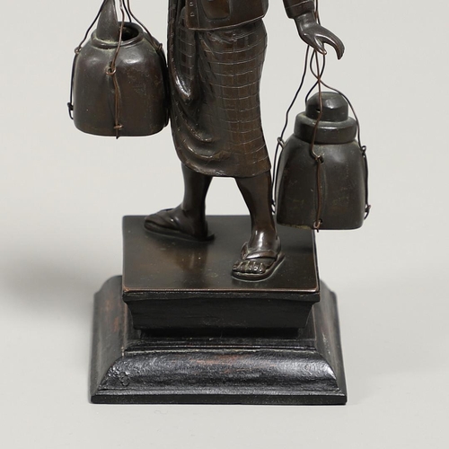 846 - SOUTH EAST ASIAN BRONZE FISHERMAN. A bronze figure of a Fisherman, carrying two storage jars suspend... 