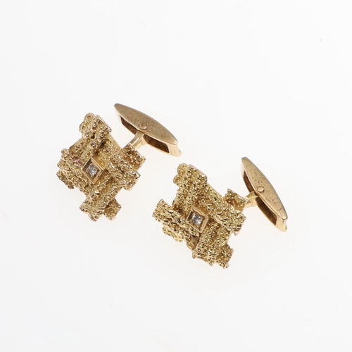 1038 - A PAIR OF GOLD AND DIAMOND CUFFLINKS. each link of textured abstract form and centred with a circula... 