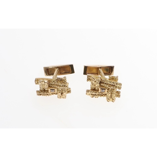 1038 - A PAIR OF GOLD AND DIAMOND CUFFLINKS. each link of textured abstract form and centred with a circula... 