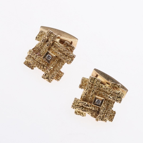 1038 - A PAIR OF GOLD AND DIAMOND CUFFLINKS. each link of textured abstract form and centred with a circula... 