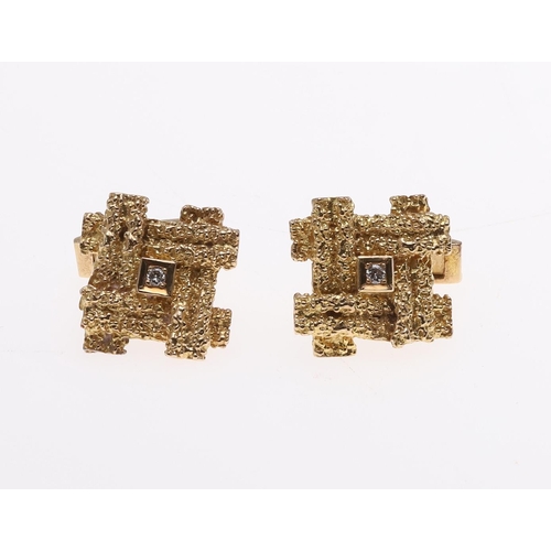 1038 - A PAIR OF GOLD AND DIAMOND CUFFLINKS. each link of textured abstract form and centred with a circula... 