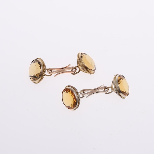 1042 - A PAIR OF CITRINE & GOLD CUFFLINKS. each link mounted with a circular-cut citrine, in gold mounts.  ... 