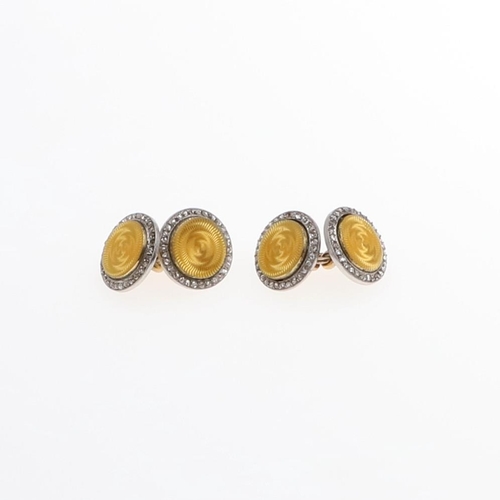 1044 - A PAIR OF DIAMOND AND ENAMEL CUFFLINKS BY CARTIER. each formed with a circular section of yellow gui... 