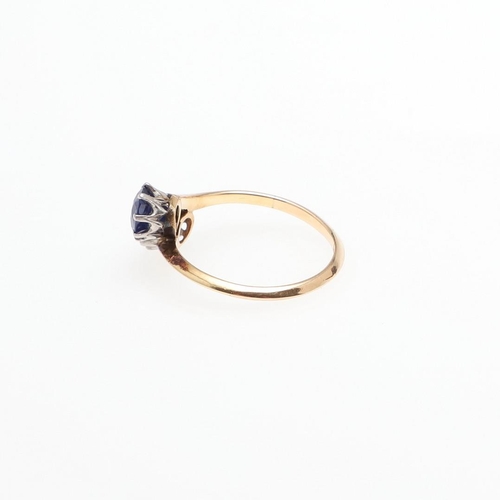 1053 - A SAPPHIRE AND DIAMOND TWO STONE CROSS-OVER RING. mounted with a circular-cut sapphire and a circula... 