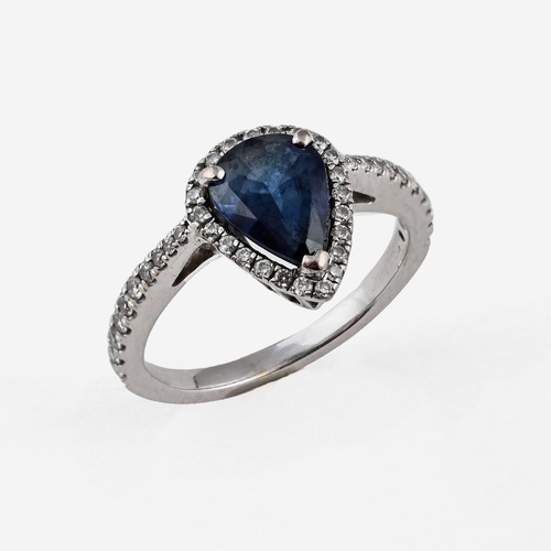 1054 - A SAPPHIRE AND DIAMOND CLUSTER RING. the pear-shaped sapphire weighs approximately 1.50 carats and i... 