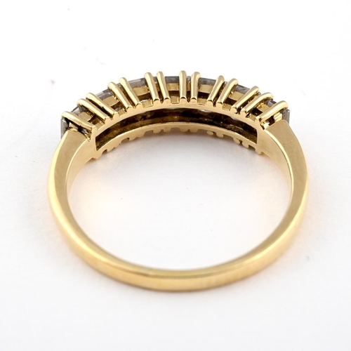 1055 - A DIAMOND HALF HOOP RING. mounted with seven princess-cut diamonds in 18ct yellow gold. Size Q.  *CR... 