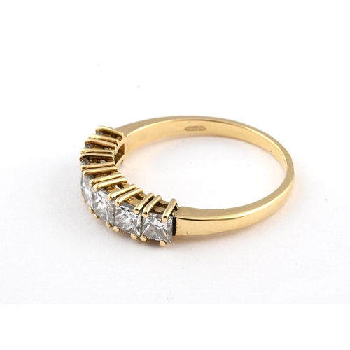 1055 - A DIAMOND HALF HOOP RING. mounted with seven princess-cut diamonds in 18ct yellow gold. Size Q.  *CR... 