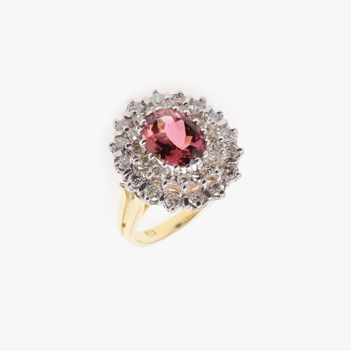 1066 - A PINK TOURMALINE AND DIAMOND CLUSTER RING. the oval-shaped pink tourmaline is set within a double s... 