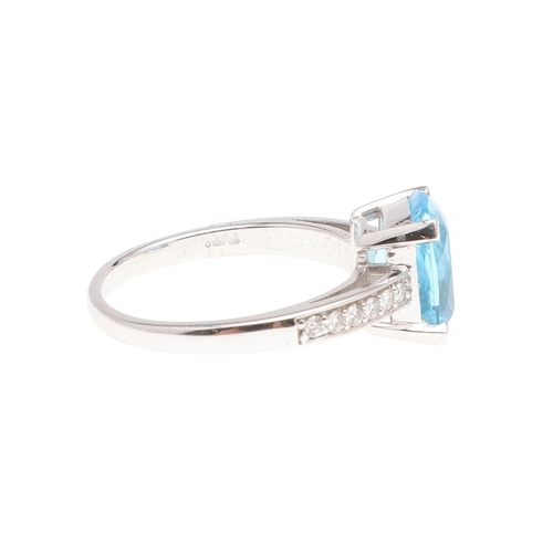 1071 - A BLUE TOPAZ AND DIAMOND RING. the rounded rectangular-shaped blue topaz is set with circular-cut di... 