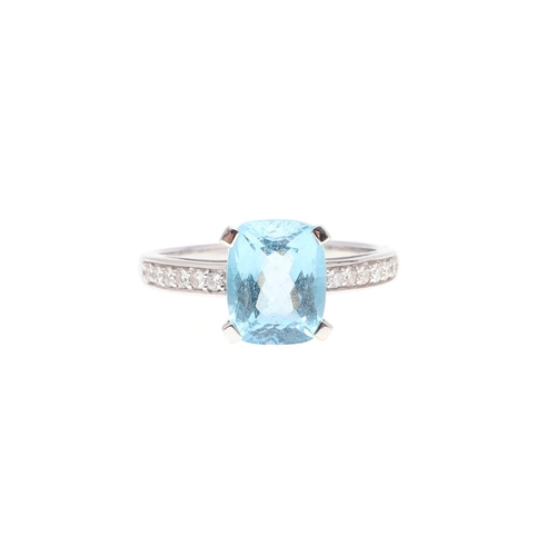 1071 - A BLUE TOPAZ AND DIAMOND RING. the rounded rectangular-shaped blue topaz is set with circular-cut di... 