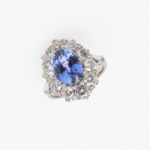 1293 - A SAPPHIRE AND DIAMOND CLUSTER RING. the oval-shaped sapphire weighs 4.50 carats and is set within a... 