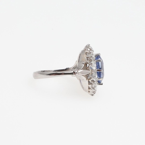 1293 - A SAPPHIRE AND DIAMOND CLUSTER RING. the oval-shaped sapphire weighs 4.50 carats and is set within a... 