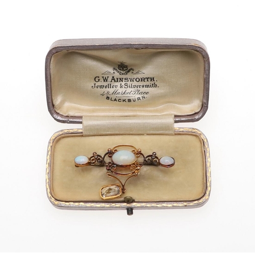 900 - AN OPAL AND GOLD BROOCH. the gold openwork mount is set with three oval solid white opals, suspendin... 