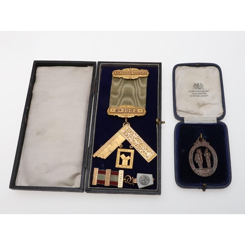 912 - A 9CT GOLD MASONIC MEDAL. mounted on a pale green ribbon, 25 grams, together with two other items.  ... 