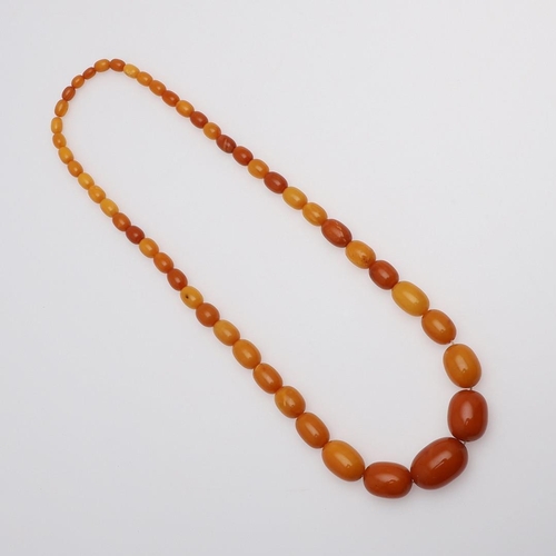 926 - A SINGLE ROW GRADUATED AMBER BEAD NECKLACE. 76cm long, 91 grams.  *CR  With some wear to the beads.