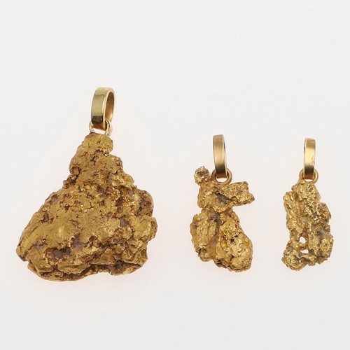 936 - A GOLD NUGGET PENDANT. 2cm long, together with two smaller nugget pendants, total weight of pendants... 