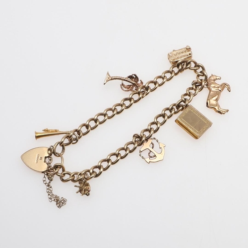 953 - A 9CT GOLD CURB LINK BRACELET. with padlock clasp and suspending assorted gold charms, 21cm long, 26... 