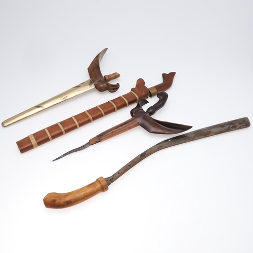 145 - A KRIS TYPE DAGGER AND THREE OTHERS. A Kris type dagger with a 33cm in an oversized scabbard with el... 