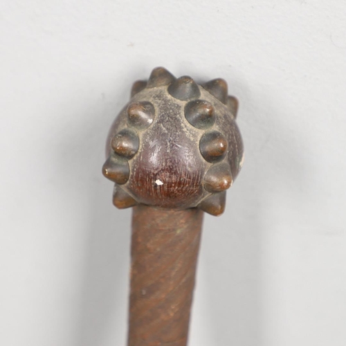 148 - AN AFRICAN TRIBAL CLUB WITH STUDDED HEAD. A tribal club with a round head with a cross pattern of se... 