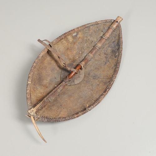 151 - A KENYAN MASAI SHIELD WITH RED AND BLACK FINISH. A 19th Century Kenyan leather covered shield, the o... 