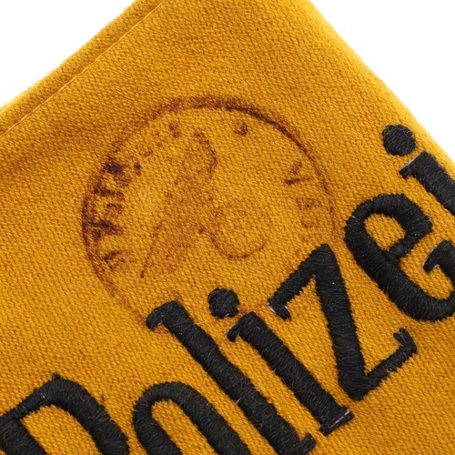 172 - A SECOND WORLD WAR 'DEUTSCHE POLIZEI' ARMBAND WITH STAMP. A machine woven 'Deutsche Polizei' armband... 