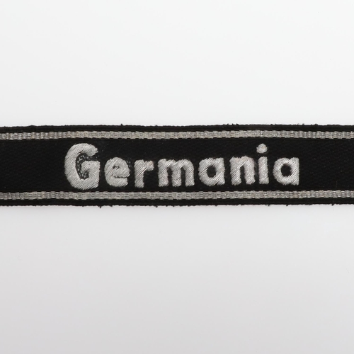 240 - A SECOND WORLD WAR GERMAN 'GERMANIA' CUFF TITLE. A machine embroidered cuff title 'Germania' in silv... 
